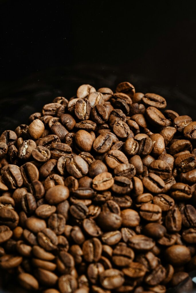 Whole coffee beans in a black ceramic bowl