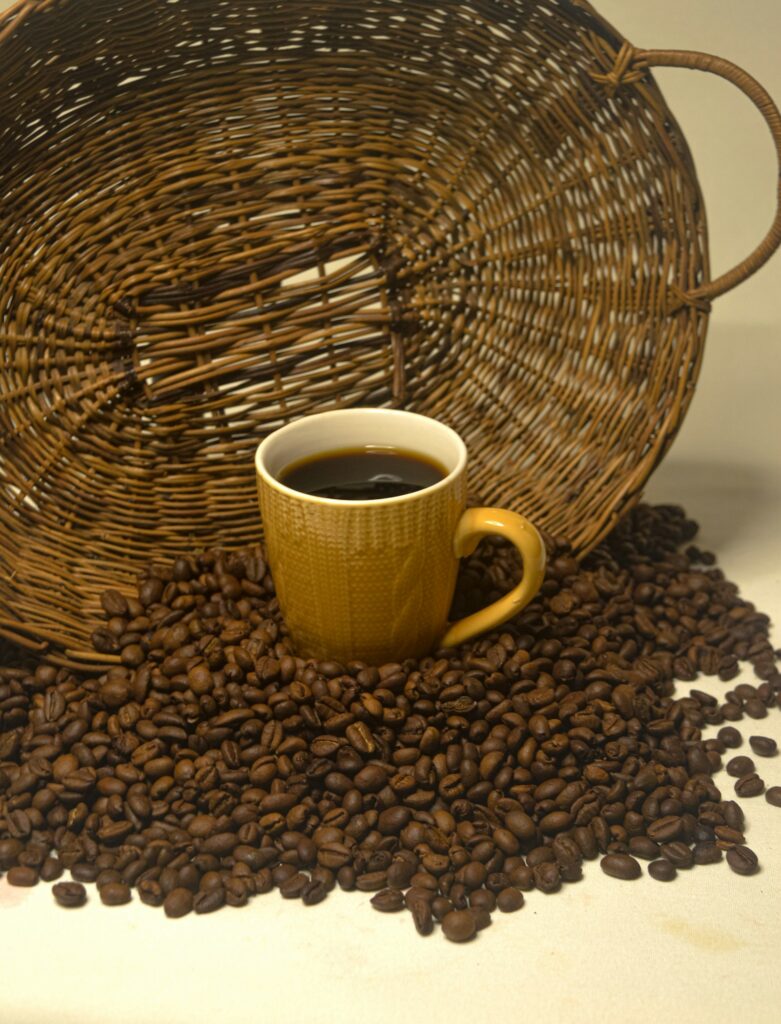 Cup of coffee resting on a pile of coffee beans