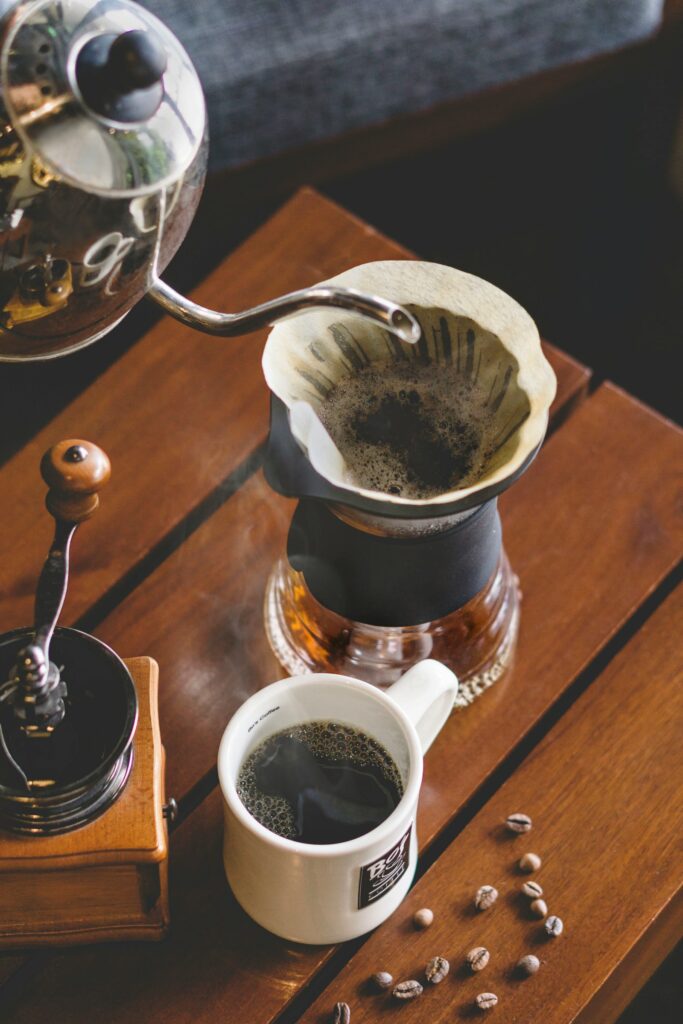 A cup of coffee beside a coffee grinder