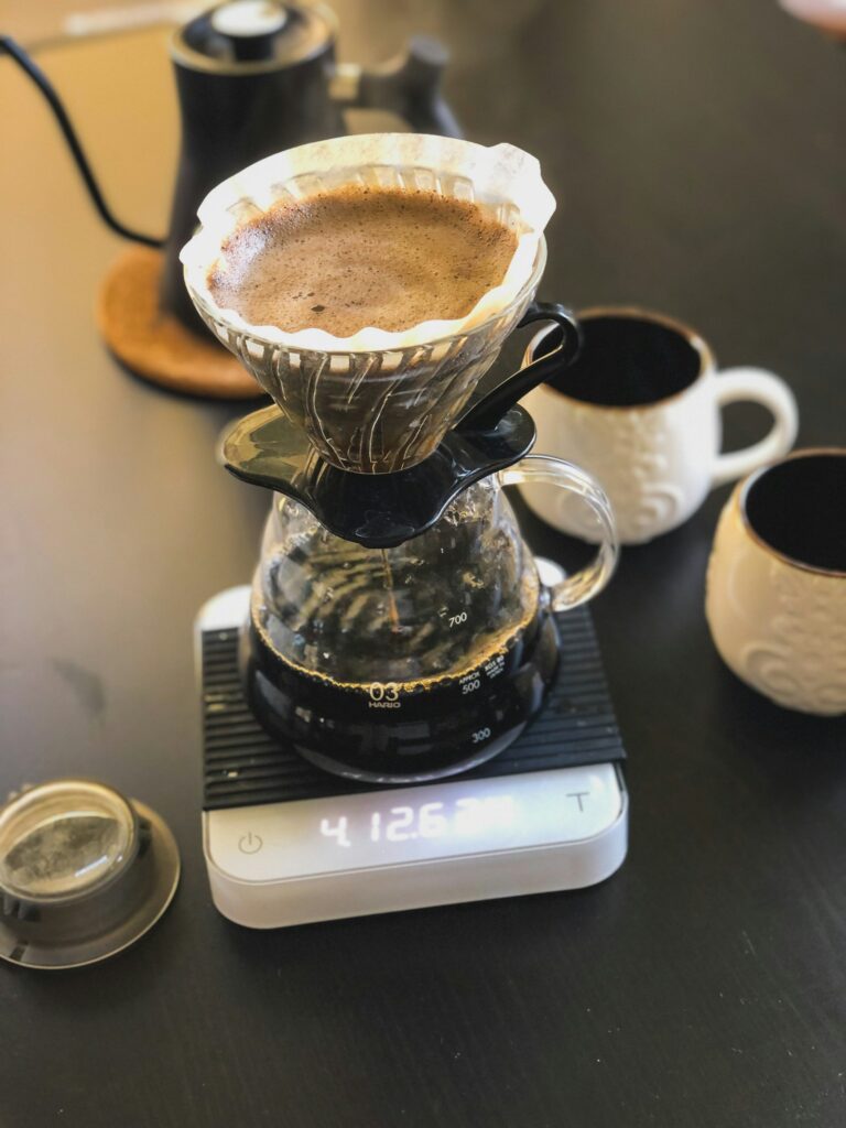Pour-over dripper brewing coffee into a ceramic cup