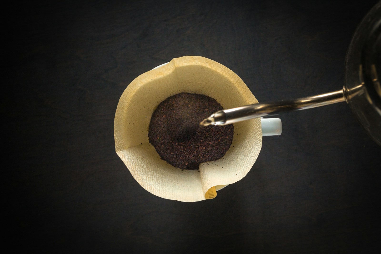 Hot water poured over ground coffee in a pour-over dripper, seen from above